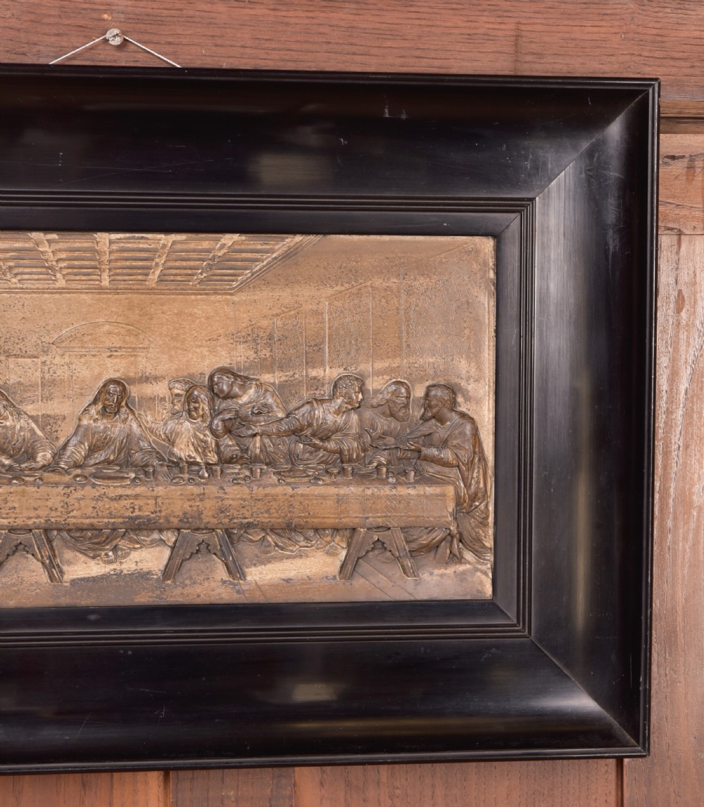 A 19th-century cast metal high-relief plaque depicting The Last Supper mounted inside a deep, black ebonised wooden frame. View VI