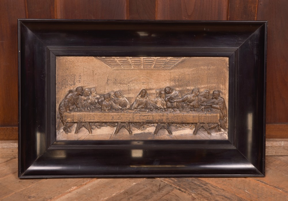 A 19th-century cast metal high-relief plaque depicting The Last Supper mounted inside a deep, black ebonised wooden frame. View X