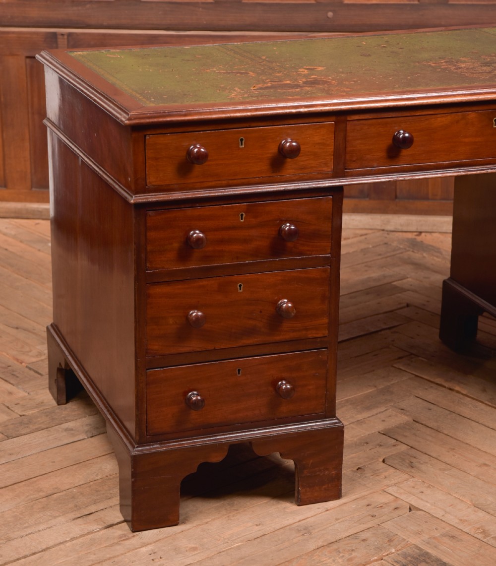 A Victorian mahogany pedestal desk with a green inset leather writing surface, multiple drawers fitted with turned wooden handles, and pedestal bases with bracket feet. View III