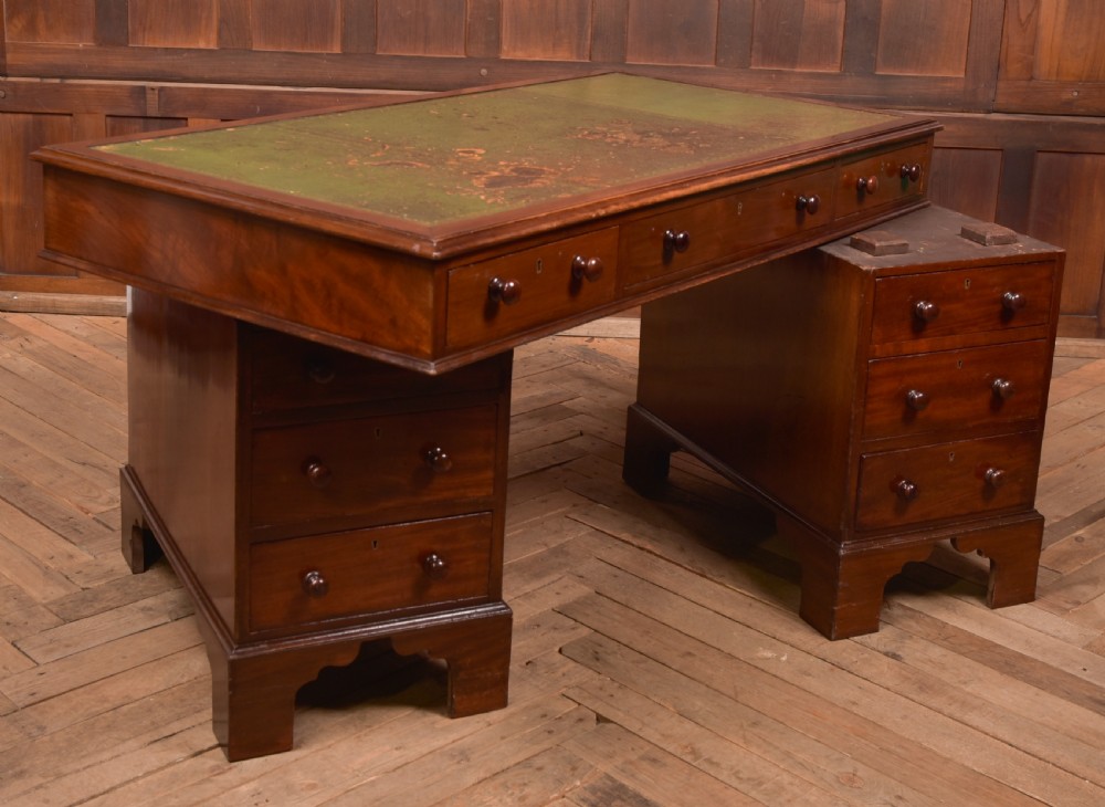 A Victorian mahogany pedestal desk with a green inset leather writing surface, multiple drawers fitted with turned wooden handles, and pedestal bases with bracket feet. View XI