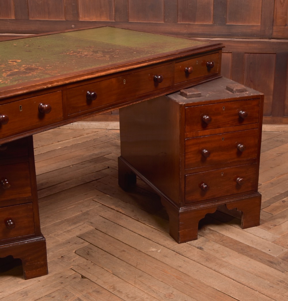 A Victorian mahogany pedestal desk with a green inset leather writing surface, multiple drawers fitted with turned wooden handles, and pedestal bases with bracket feet. View XIII