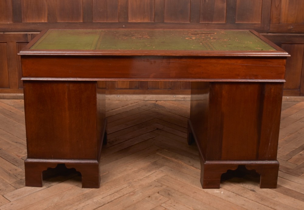 A Victorian mahogany pedestal desk with a green inset leather writing surface, multiple drawers fitted with turned wooden handles, and pedestal bases with bracket feet. View XVIII