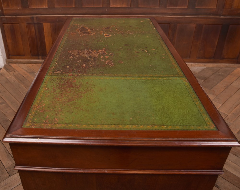 A Victorian mahogany pedestal desk with a green inset leather writing surface, multiple drawers fitted with turned wooden handles, and pedestal bases with bracket feet. View XX