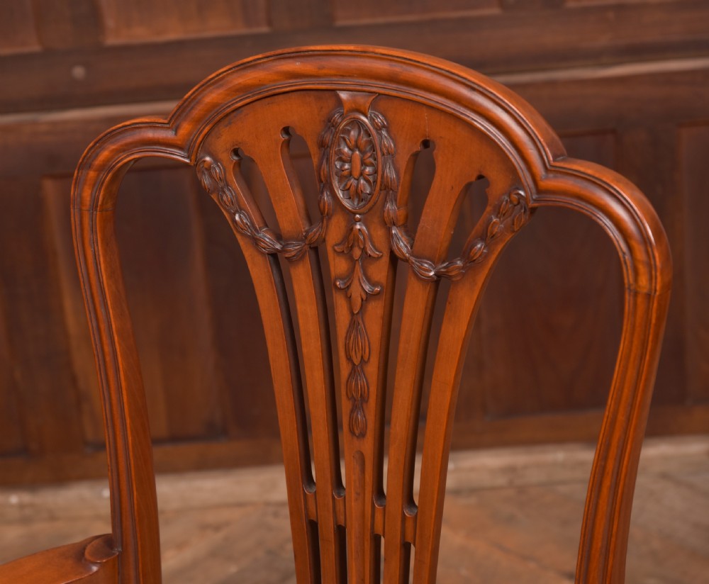 An Edwardian satinwood armchair with a carved pierced splat back, sweeping armrests, and a striped gold upholstered seat. View III