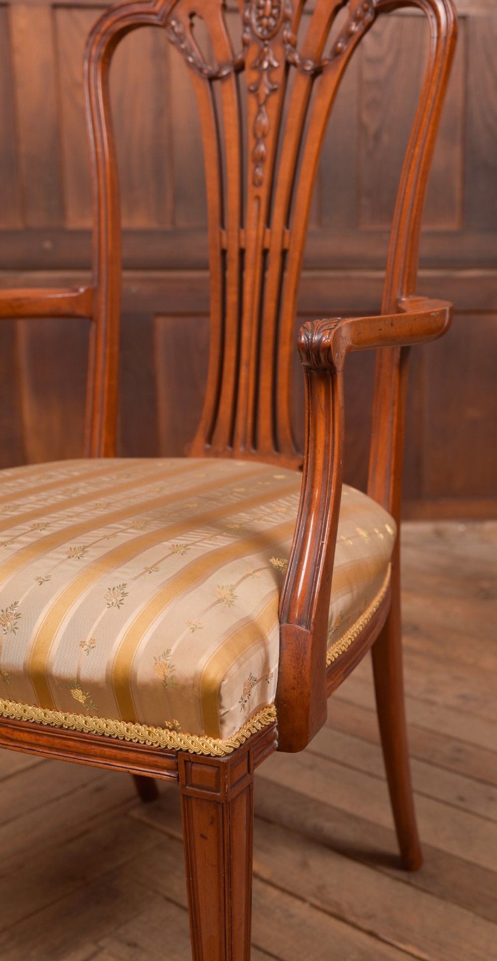 An Edwardian satinwood armchair with a carved pierced splat back, sweeping armrests, and a striped gold upholstered seat. View VII