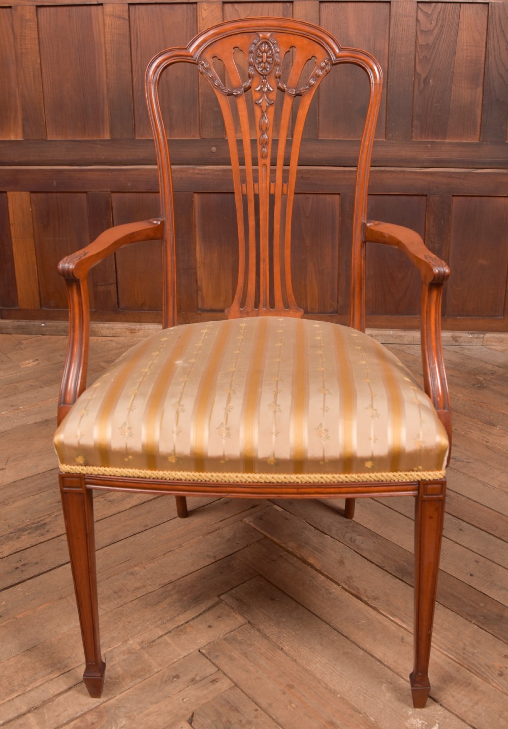 An Edwardian satinwood armchair with a carved pierced splat back, sweeping armrests, and a striped gold upholstered seat. View VIII
