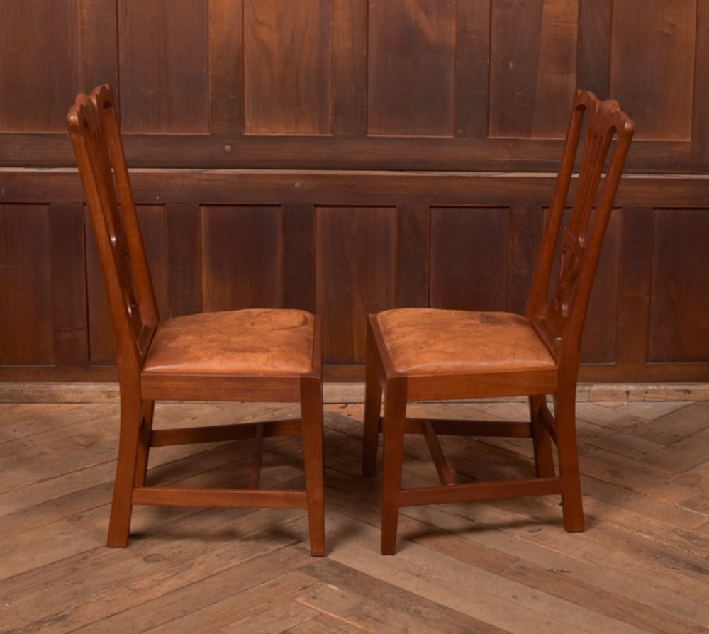 A matching pair of warm brown walnut side chairs with pierced vasiform splats, shaped crest rails, and upholstered drop-in seats supported by square legs with H-stretchers. View II