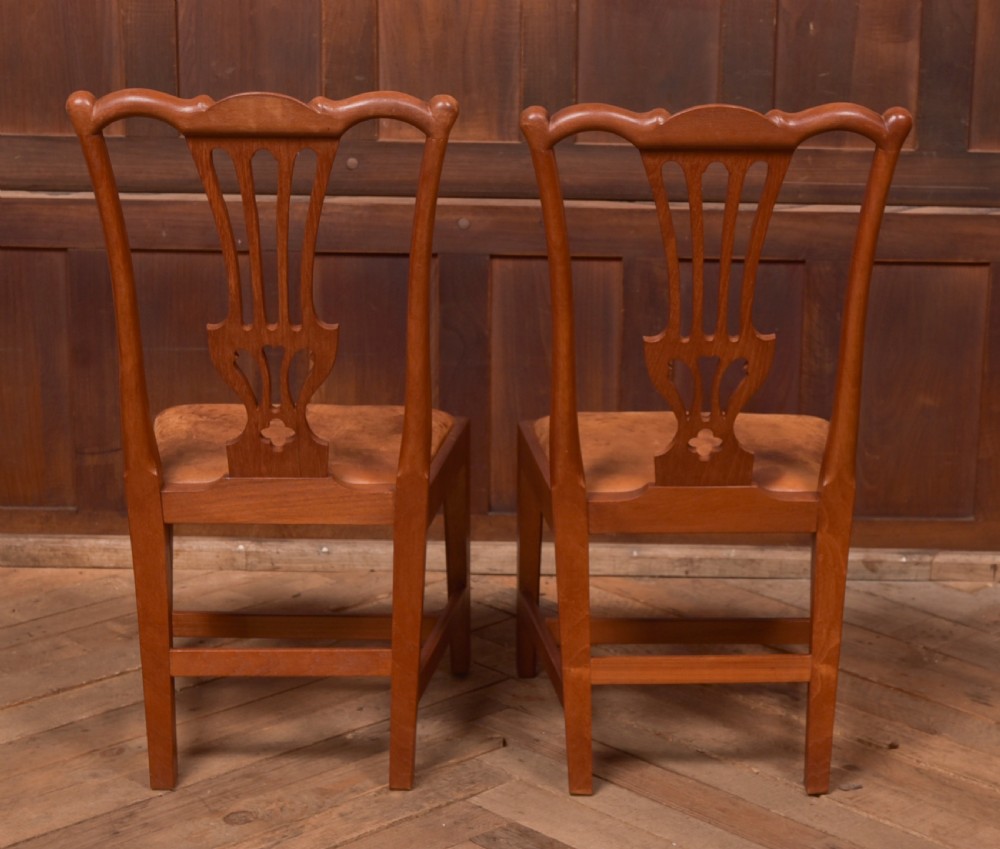 A matching pair of warm brown walnut side chairs with pierced vasiform splats, shaped crest rails, and upholstered drop-in seats supported by square legs with H-stretchers. View IV