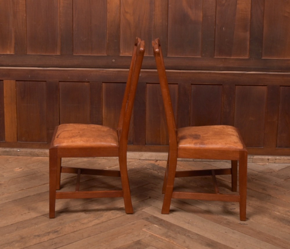 A matching pair of warm brown walnut side chairs with pierced vasiform splats, shaped crest rails, and upholstered drop-in seats supported by square legs with H-stretchers. View VIII