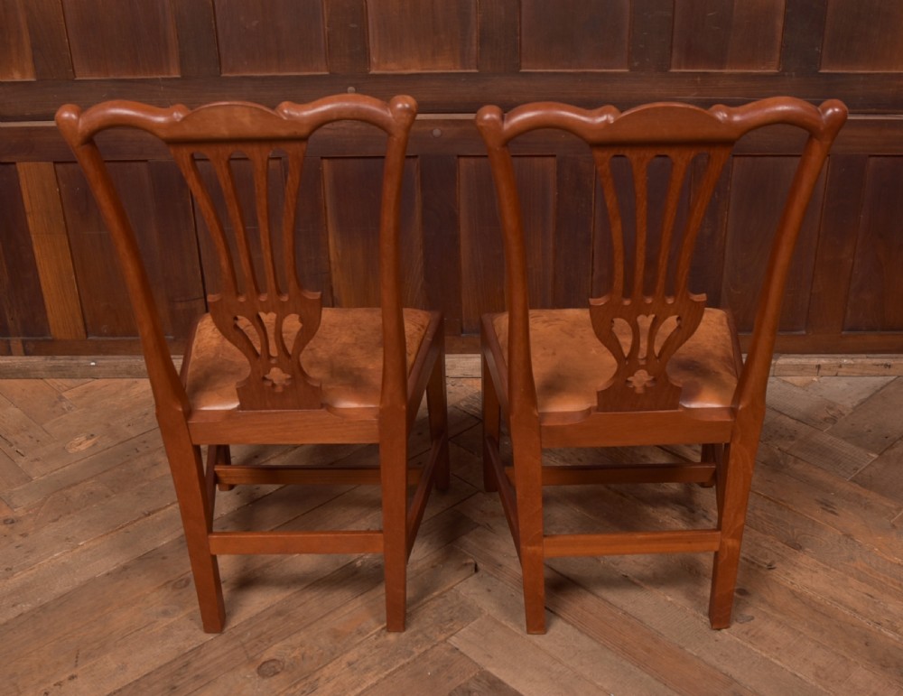 A matching pair of warm brown walnut side chairs with pierced vasiform splats, shaped crest rails, and upholstered drop-in seats supported by square legs with H-stretchers. View IX