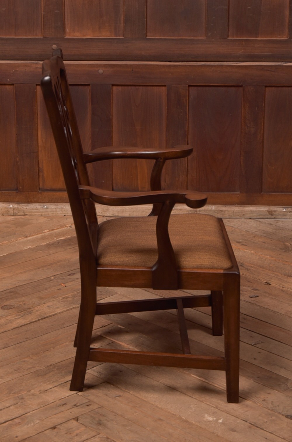 A dark hardwood open armchair featuring a pierced carved back splat, curved armrests, and a textured brown upholstered drop-in seat. View III
