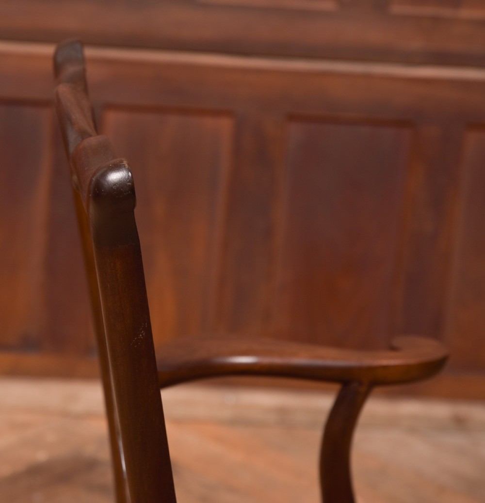A dark hardwood open armchair featuring a pierced carved back splat, curved armrests, and a textured brown upholstered drop-in seat. View V