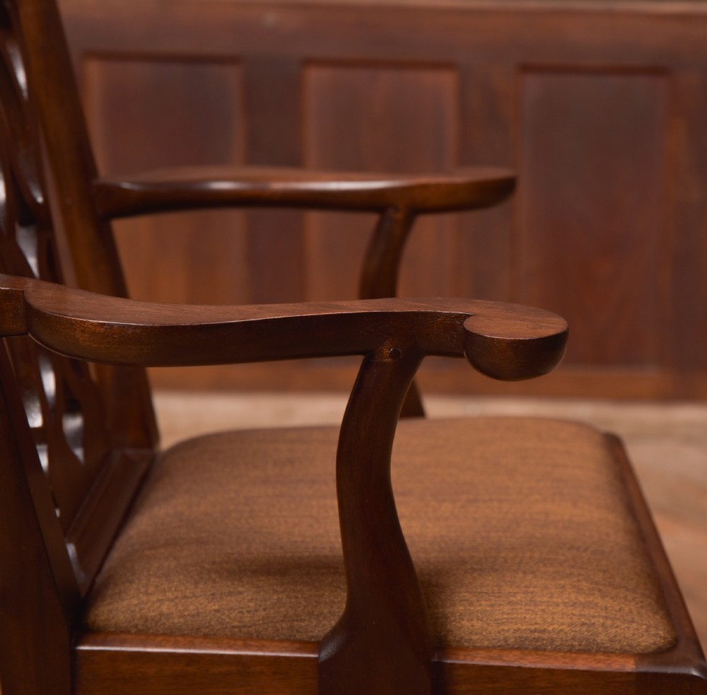 A dark hardwood open armchair featuring a pierced carved back splat, curved armrests, and a textured brown upholstered drop-in seat. View VI