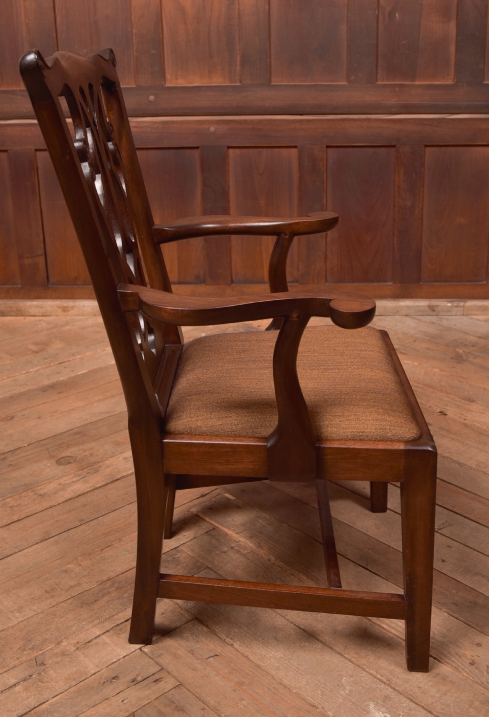 A dark hardwood open armchair featuring a pierced carved back splat, curved armrests, and a textured brown upholstered drop-in seat. View VII
