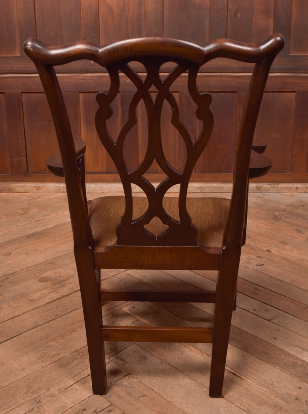 A dark hardwood open armchair featuring a pierced carved back splat, curved armrests, and a textured brown upholstered drop-in seat. View VIII