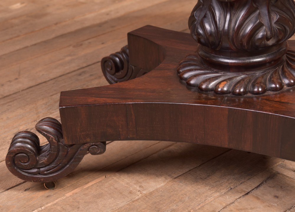 A Victorian rosewood fold-over card table featuring a rectangular swivel top, carved frieze, central column support, and a quadform base with scroll feet. View VII