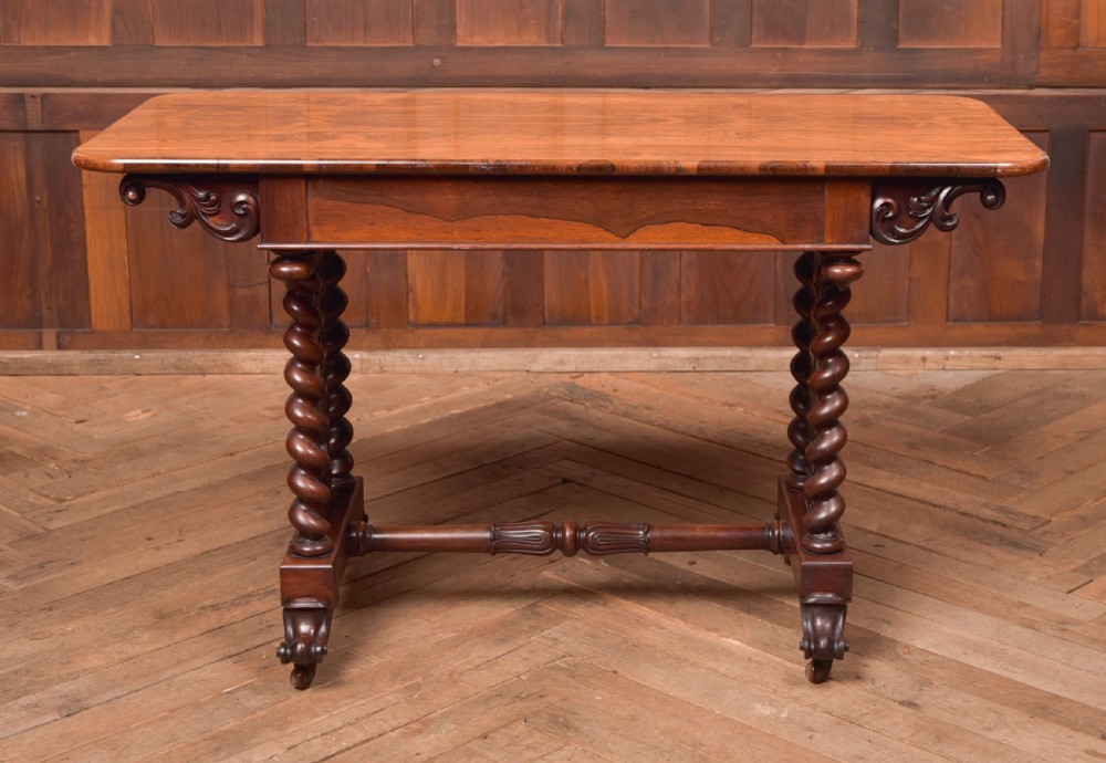 A Victorian wooden side table featuring a rectangular top with rounded corners, carved scroll brackets, double barley twist legs, a central stretcher, and castors. View VIII