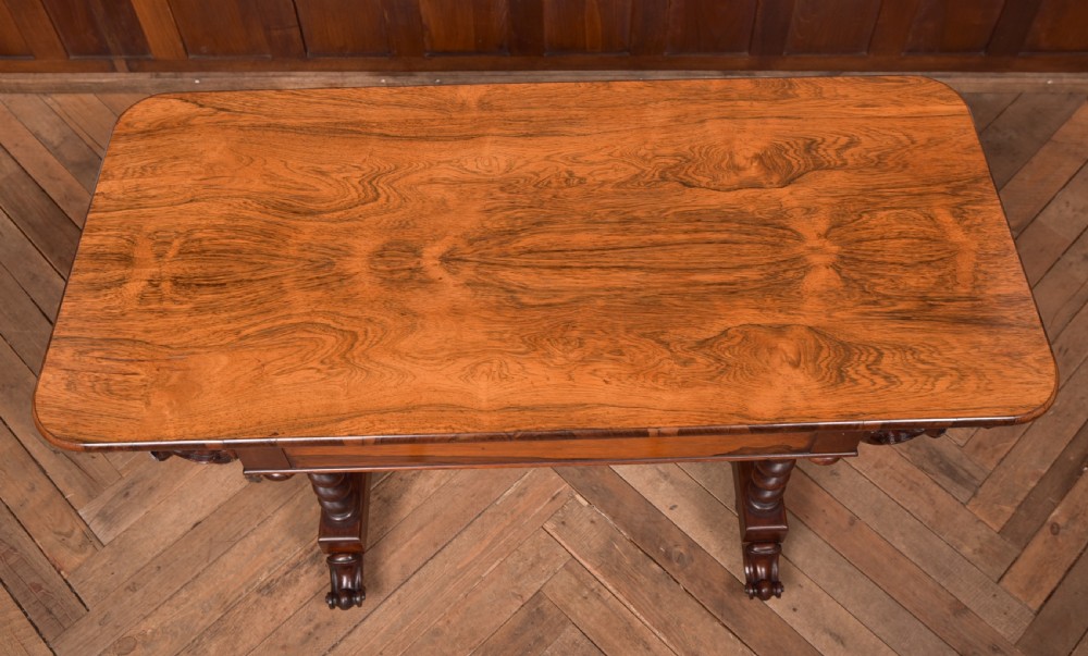 A Victorian wooden side table featuring a rectangular top with rounded corners, carved scroll brackets, double barley twist legs, a central stretcher, and castors. View XII