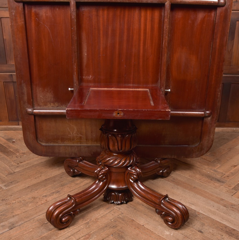 A Victorian mahogany tilt-top table featuring a polished rectangular top with rounded corners set upon a carved pedestal stem with quadruped scrolled legs. View IX