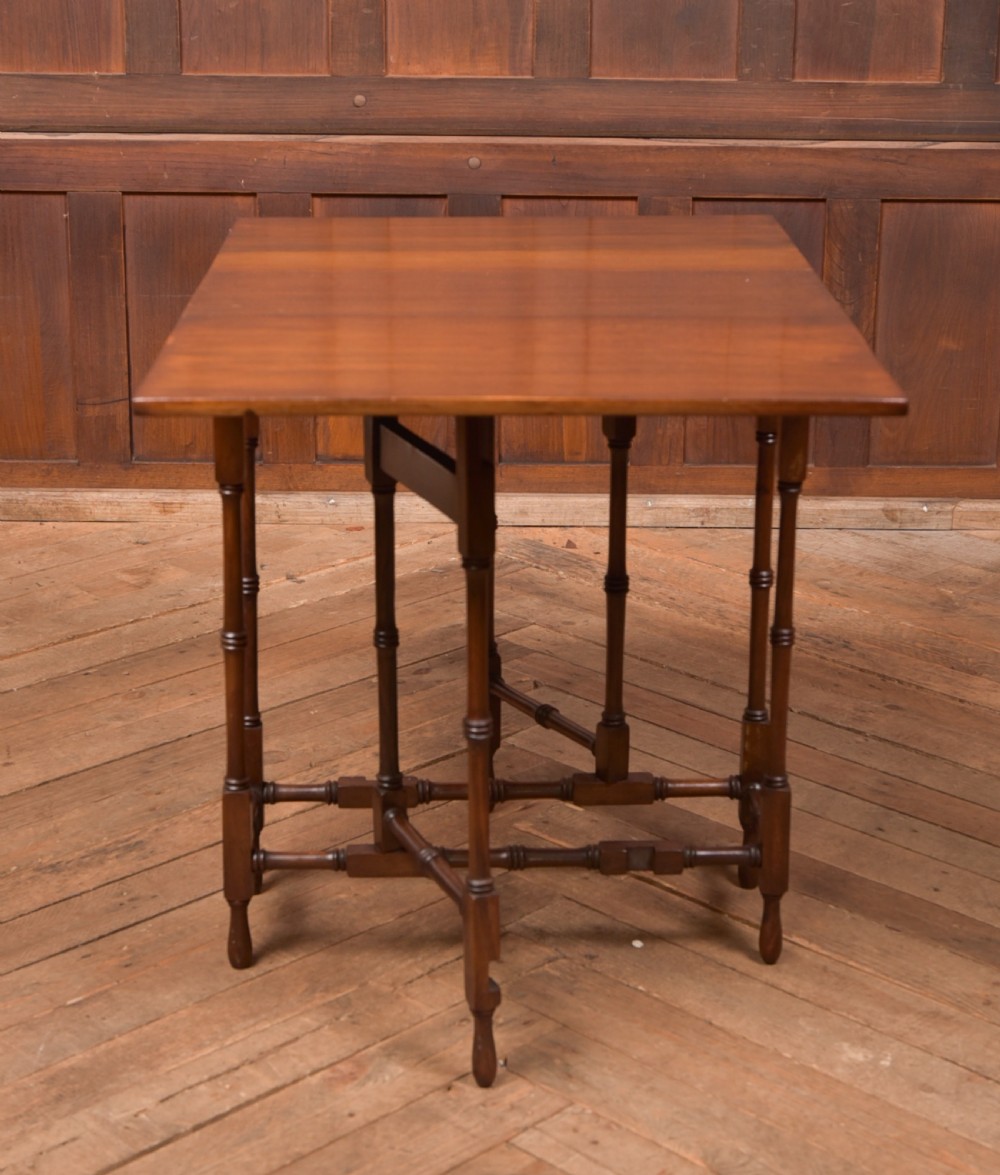 An Edwardian mahogany drop-leaf table with turned legs and lower stretchers, pictured with both leaves folded down. View V
