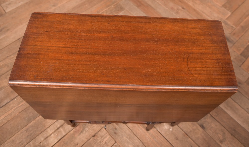An Edwardian mahogany drop-leaf table with turned legs and lower stretchers, pictured with both leaves folded down. View X