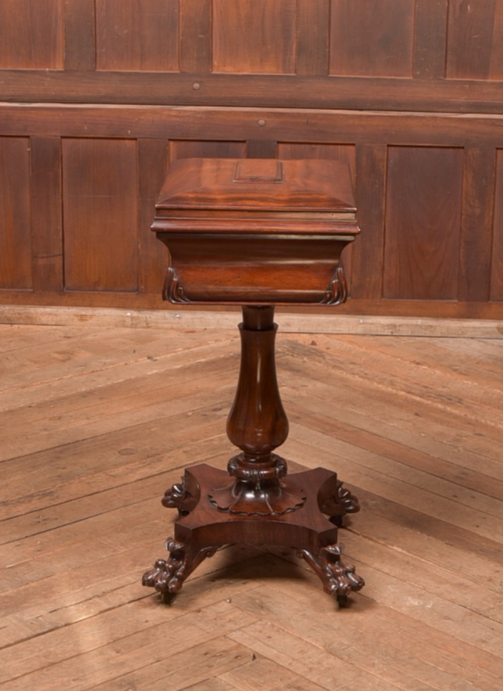 A Victorian rosewood work table featuring a hinged sarcophagus lid, a turned pedestal column, and a carved quadruped base on brass castors. View XI