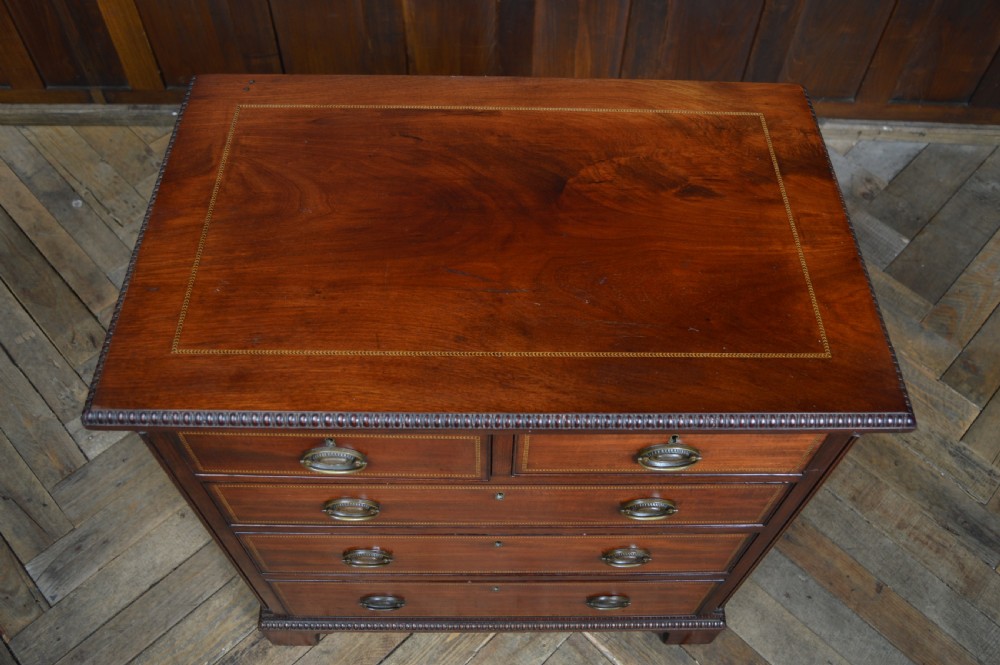 An Edwardian mahogany chest of drawers featuring two short over three long drawers with boxwood stringing inlay, brass oval drop handles, and bracket feet. View II
