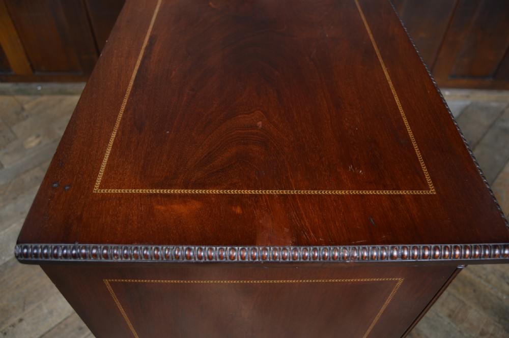 An Edwardian mahogany chest of drawers featuring two short over three long drawers with boxwood stringing inlay, brass oval drop handles, and bracket feet. View VIII