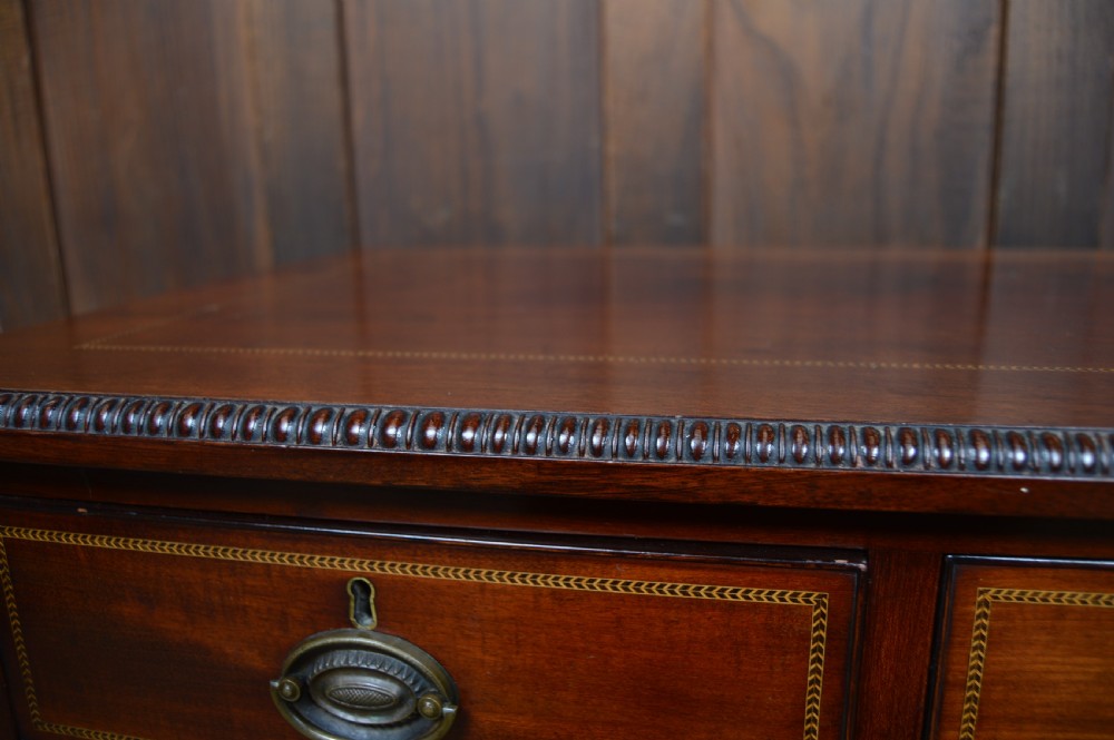 An Edwardian mahogany chest of drawers featuring two short over three long drawers with boxwood stringing inlay, brass oval drop handles, and bracket feet. View XXVIII