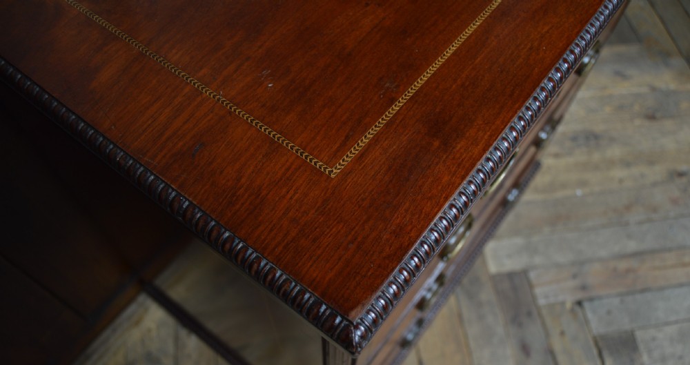 An Edwardian mahogany chest of drawers featuring two short over three long drawers with boxwood stringing inlay, brass oval drop handles, and bracket feet. View XXIX