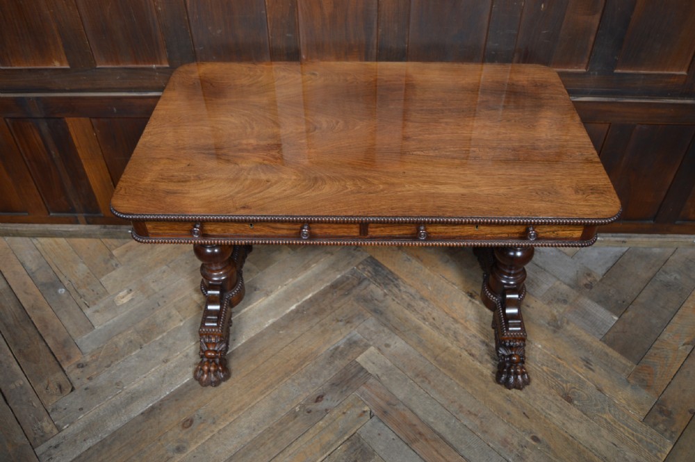 A William IV dark rosewood library side table featuring two frieze drawers with wooden knobs, beaded edge details, turned column supports, and carved claw feet. View VI