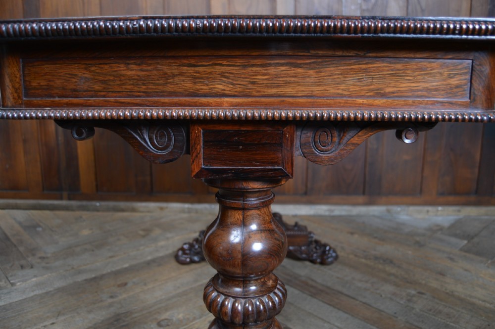 A William IV dark rosewood library side table featuring two frieze drawers with wooden knobs, beaded edge details, turned column supports, and carved claw feet. View XIV