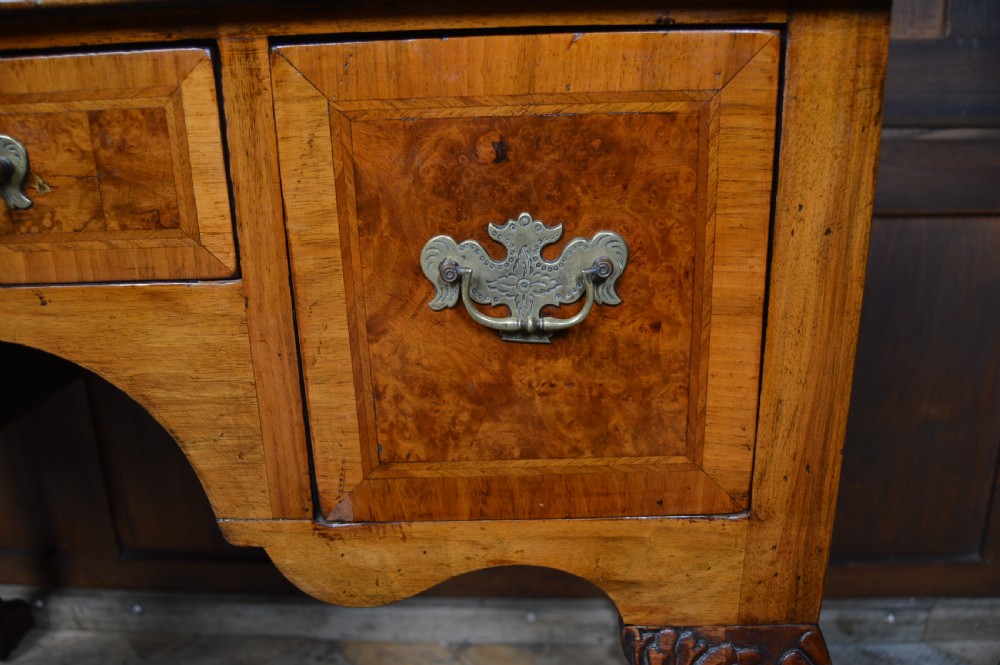 A Georgian style burr walnut lowboy table featuring three drawers with brass handles, a shaped apron, and carved cabriole legs ending in ball and claw feet. View X