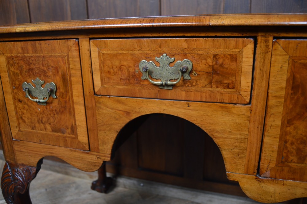A Georgian style burr walnut lowboy table featuring three drawers with brass handles, a shaped apron, and carved cabriole legs ending in ball and claw feet. View XI