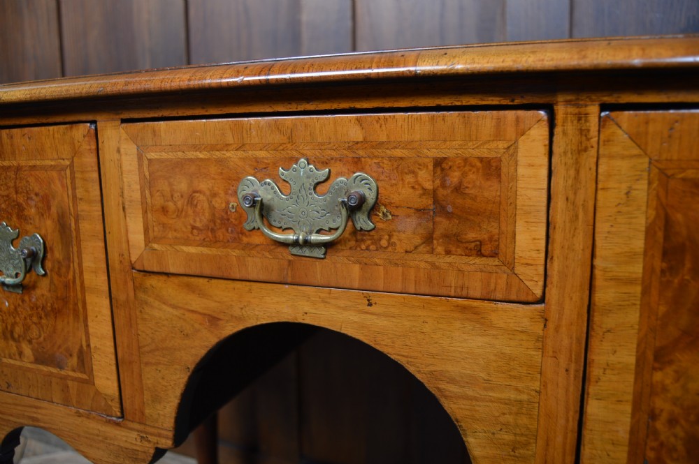 A Georgian style burr walnut lowboy table featuring three drawers with brass handles, a shaped apron, and carved cabriole legs ending in ball and claw feet. View XII