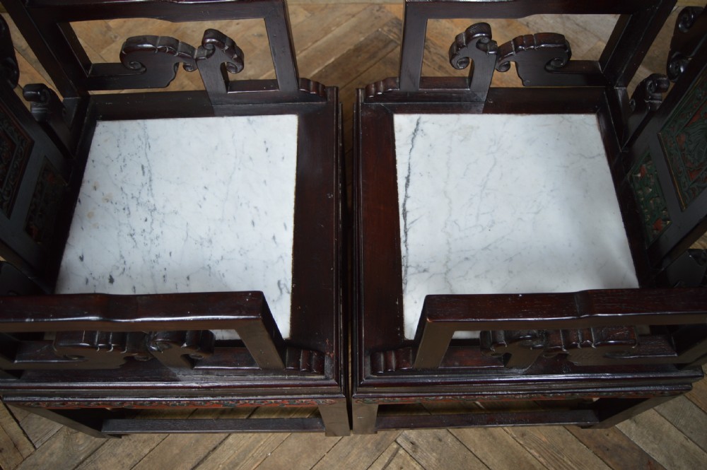 A pair of dark hardwood Chinese armchairs featuring intricate carved back panels, polychrome accents, and pale marble inset seats. View XXII