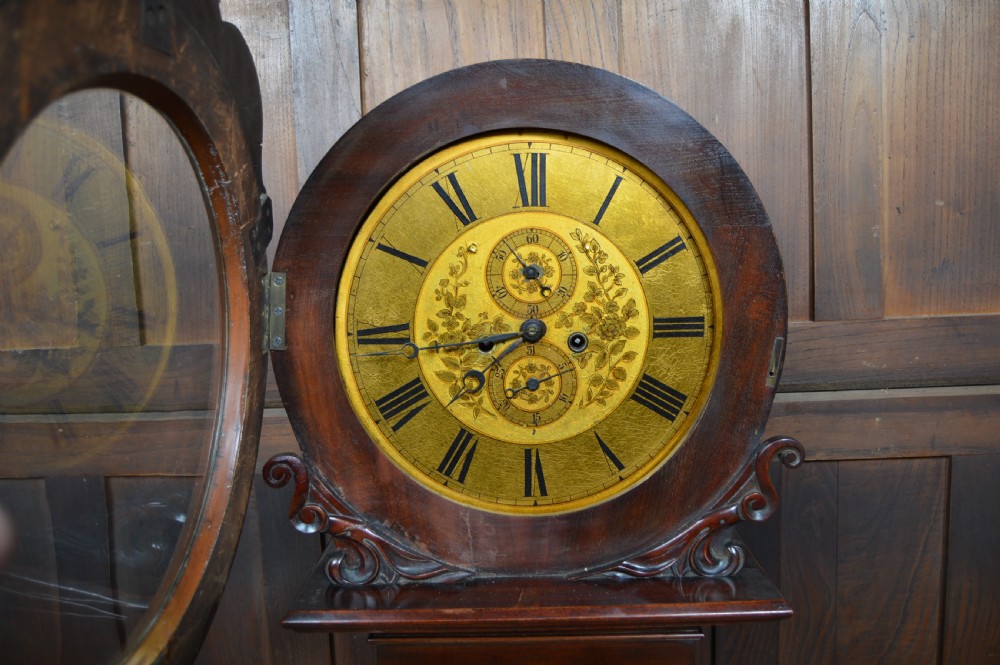 A nineteenth-century Scottish drum head longcase clock crafted from flame mahogany with an ornate circular brass dial. View VIII