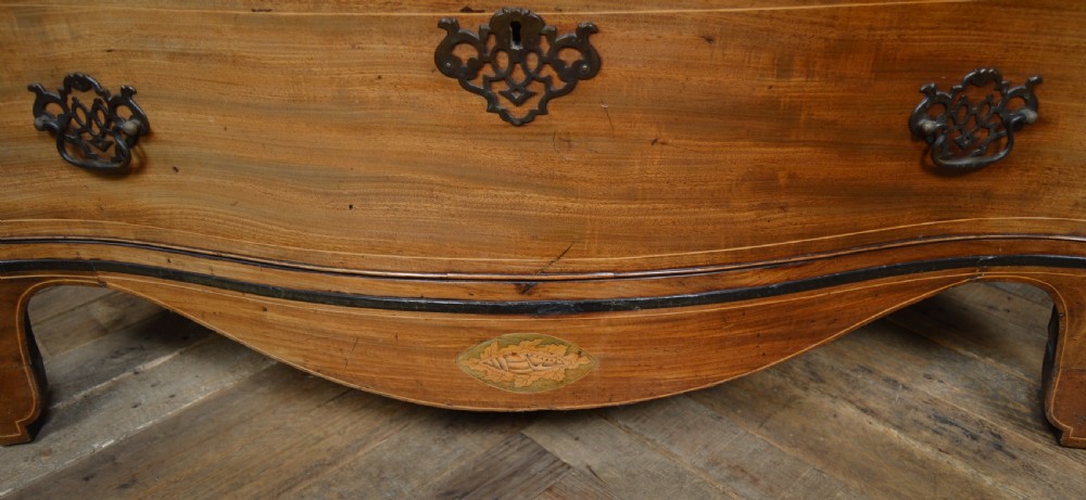 A Georgian serpentine-fronted mahogany chest featuring four graduated drawers with brass handles and inlaid border detailing. View VI