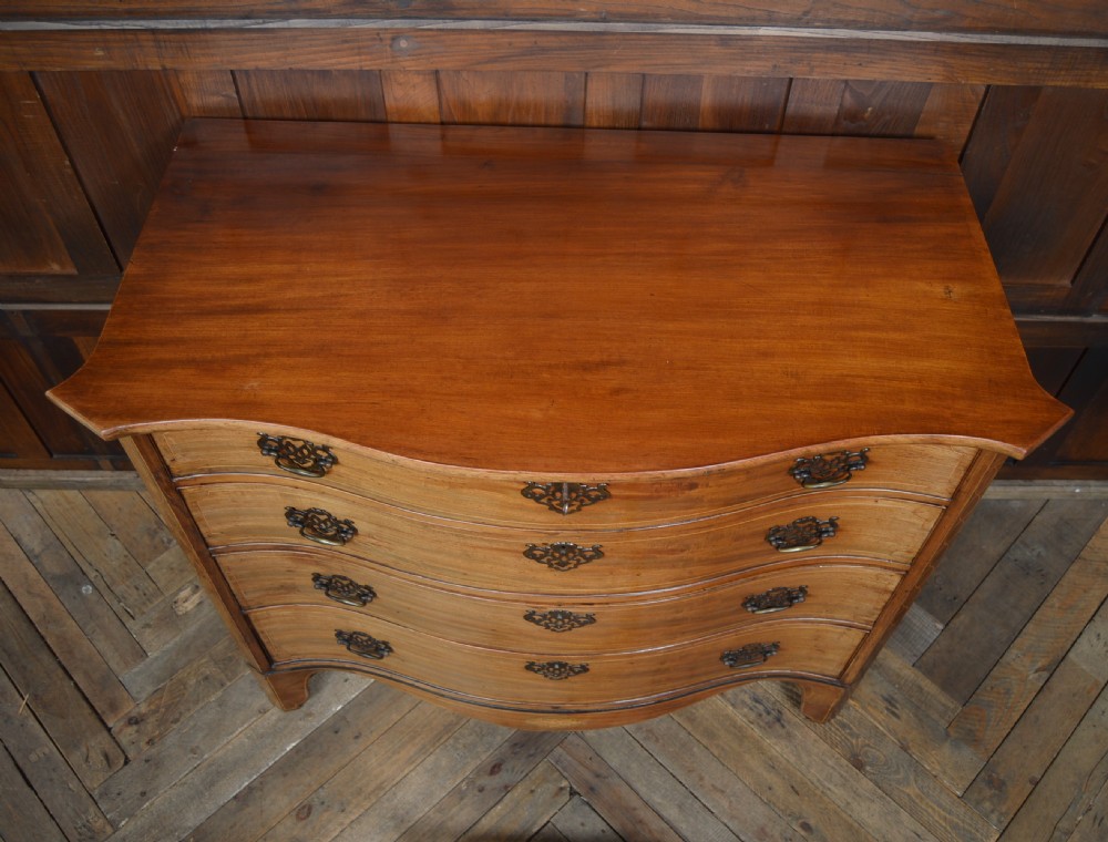 A Georgian serpentine-fronted mahogany chest featuring four graduated drawers with brass handles and inlaid border detailing. View XIII