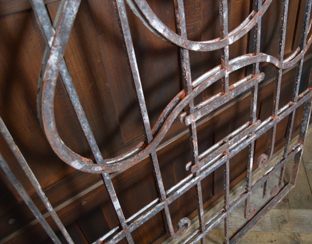 A pair of rectangular wrought iron gate panels featuring central circular scrollwork and decorative rosettes. View VI