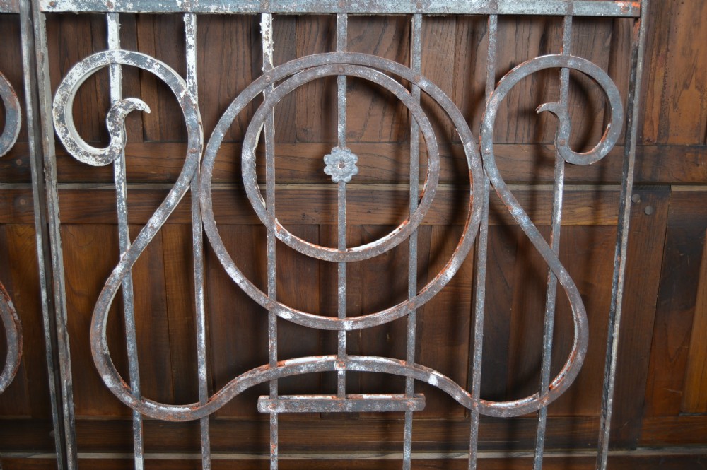 A pair of rectangular wrought iron gate panels featuring central circular scrollwork and decorative rosettes. View XI