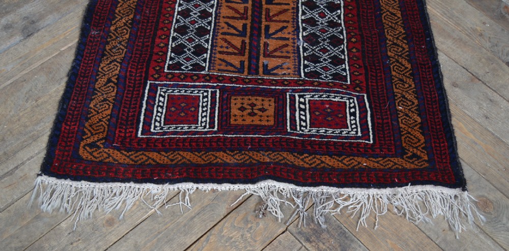 A hand-woven Belouch wool prayer rug featuring a central ochre mihrab motif surrounded by dark red and geometric patterned borders. View III