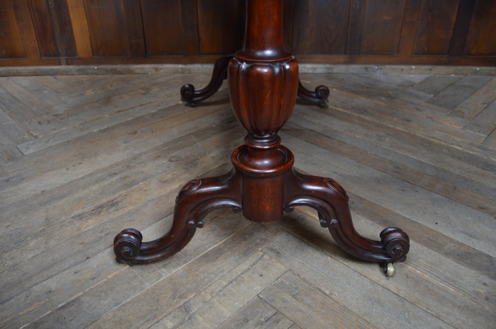 A Victorian burr walnut side table featuring a crossbanded rectangular top, two turned pedestals with a central stretcher, and carved legs with castors. View XII