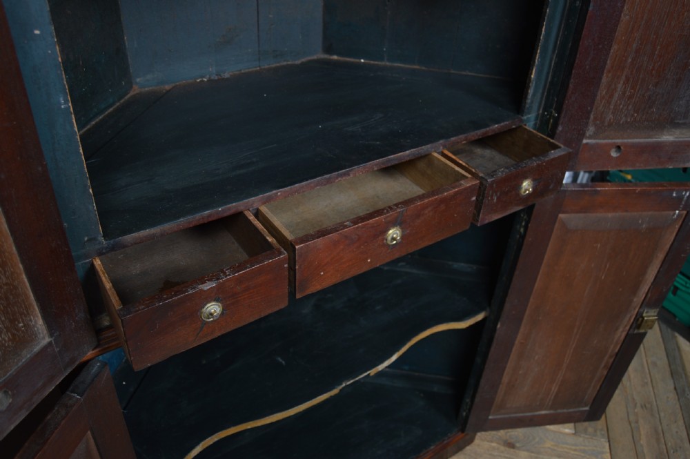 A tall freestanding Georgian corner cabinet made from mahogany featuring flame grain wood door panels and a moulded top cornice. View VII