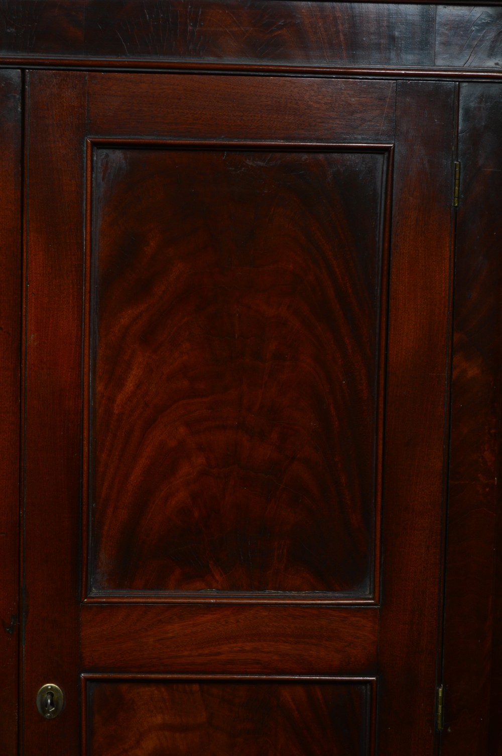 A tall freestanding Georgian corner cabinet made from mahogany featuring flame grain wood door panels and a moulded top cornice. View IX