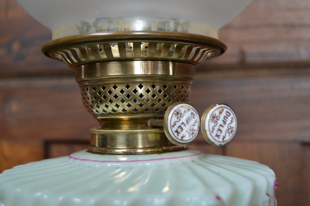 A Victorian Duplex oil lamp featuring an etched glass globe shade, hand-painted floral glass reservoir, spiralled silver-plated column, and stepped round base. View V