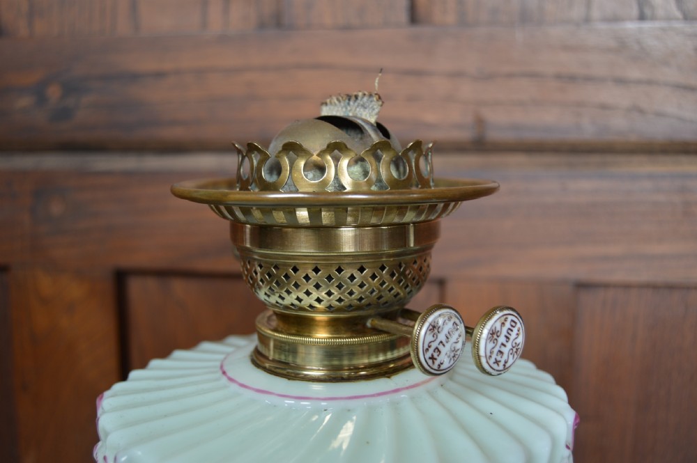 A Victorian Duplex oil lamp featuring an etched glass globe shade, hand-painted floral glass reservoir, spiralled silver-plated column, and stepped round base. View X