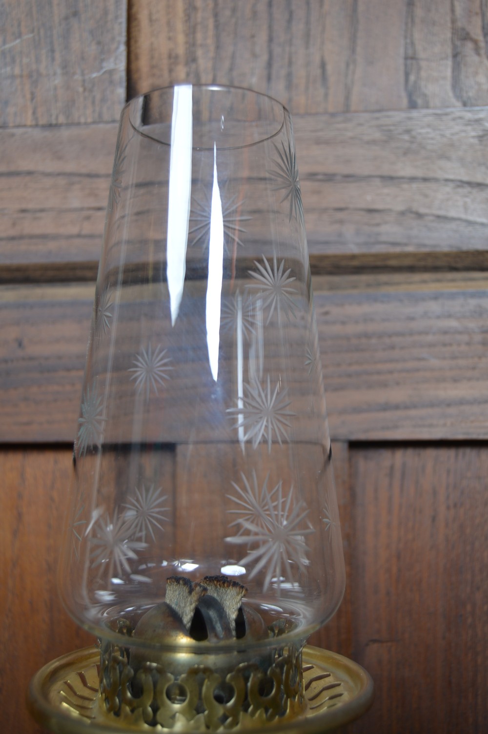 An antique brass paraffin lamp featuring a fluted base, a ribbed green glass reservoir, dual adjustment knobs, and an etched frosted glass shade. View VIII