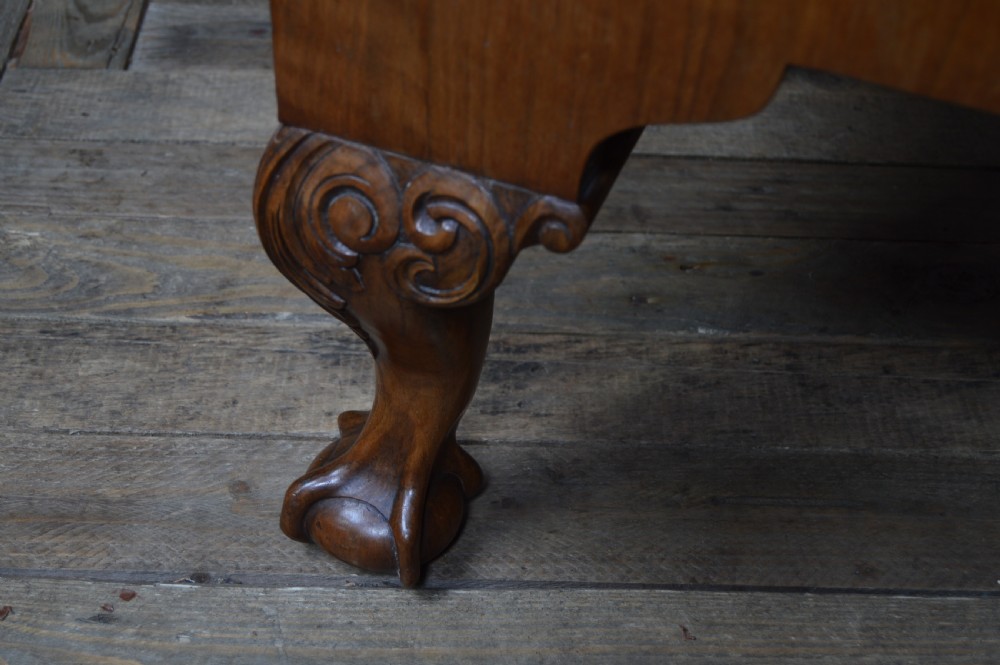 A Georgian walnut chest on stand with layered drawers, decorative brass drop handles, and carved cabriole legs. View VIII