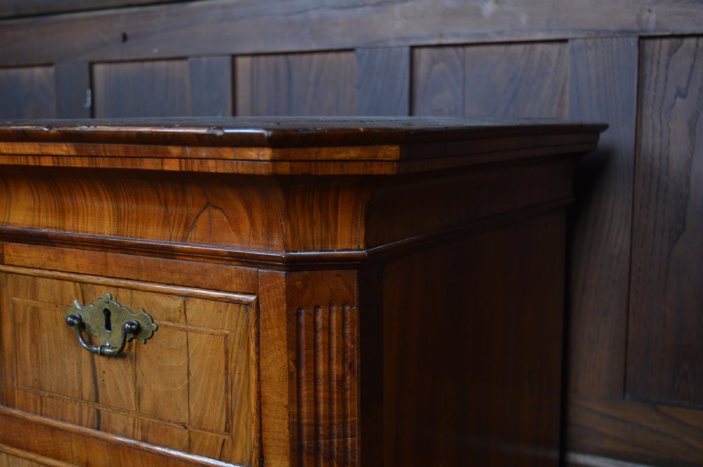 A Georgian walnut chest on stand with layered drawers, decorative brass drop handles, and carved cabriole legs. View XIII